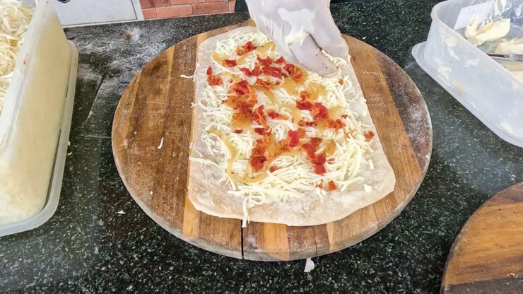 Preparare un panino con condimenti di formaggio e pomodoro