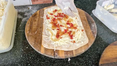 preparing a sandwich with cheese and tomato toppings.