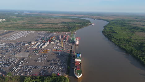 aerial view of commercial vehicle import port with cargo ships on paraná river. zarate, buenos aires, argentina.