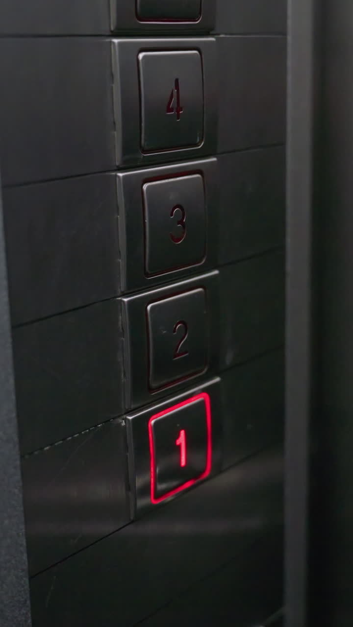 Close-up of hand pressing elevator button on metal panel. Focus on finger activating button for second floor in modern lift. Ideal for videos related to technology, office settings