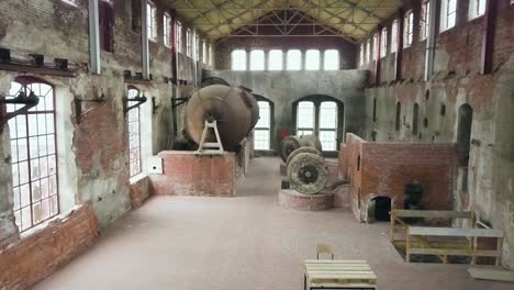 inside an abandoned strawboard factory, drone moving forward