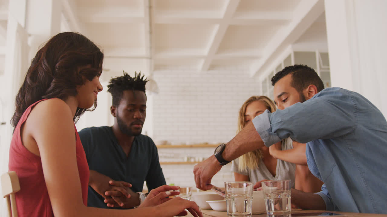 Twee stellen aan een tafel die kaarten spelen