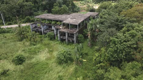 Toma-Aérea-De-Carro-Rápido-De-Una-Pequeña-Casa-Inacabada-Abandonada,-Edificio-De-Resort-En-Una-Isla-Tropical-Con-Palmeras