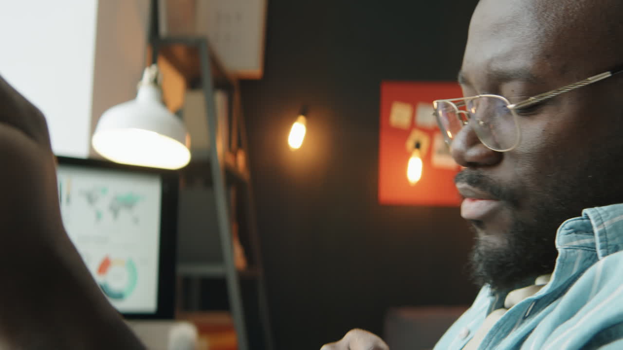 African American Man Listening to Music and Working on Laptop