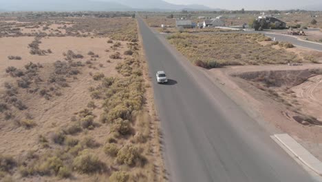 Automóvil-Conduciendo-Hacia-Adelante-A-Través-De-Un-Disparo-De-Un-Dron-De-Una-Pequeña-Ciudad