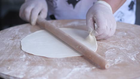 a person making dough with a rolling pin