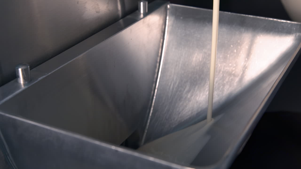 Mistura de sorvete líquida sendo despejada em um freezer comercial em câmera lenta, mostrando a textura rica e cremosa da base profissional