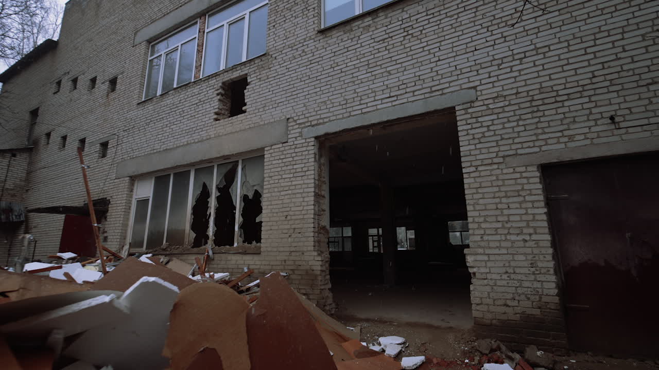 Leaving the brick wall building in a rather poor condition. A big pile of debris is outdoors under the snow.