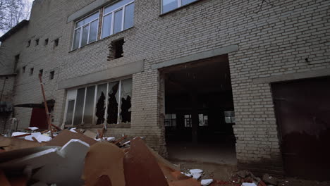 leaving the brick wall building in a rather poor condition. a big pile of debris is outdoors under the snow.