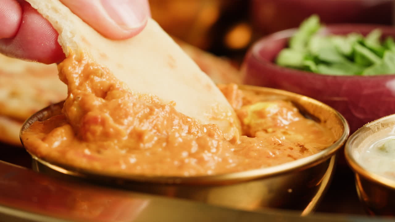 Assorted indian sri-lanka food set on wooden background. Dishes and appetisers of indeed cuisine, rice, lentils, paneer, samosa, spices, masala. Bowls and plates with indian food top view chicken. High quality 4k footage