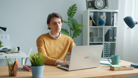hombre trabajando en una computadora portátil en una oficina moderna