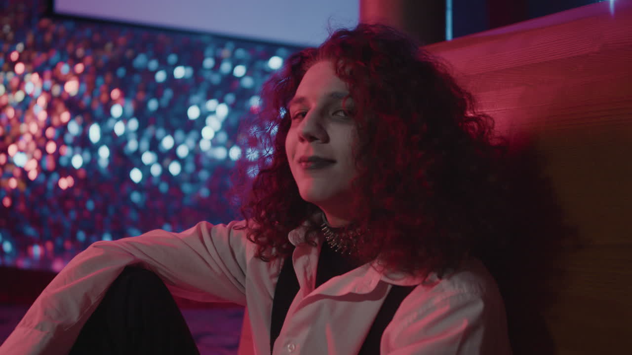 바닥에 앉아서 카메라를 쳐다보는 젊은 남자.