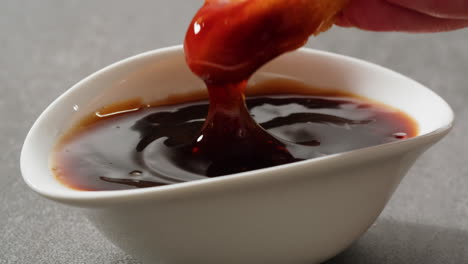dipping fried chicken in sauce