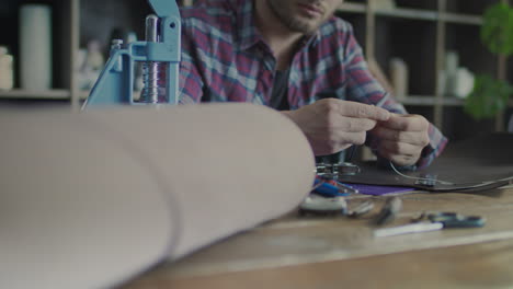 craftsman making leather wallet