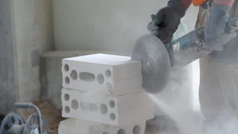 A-construction-worker-cuts-a-brick-using-an-angle-grinder