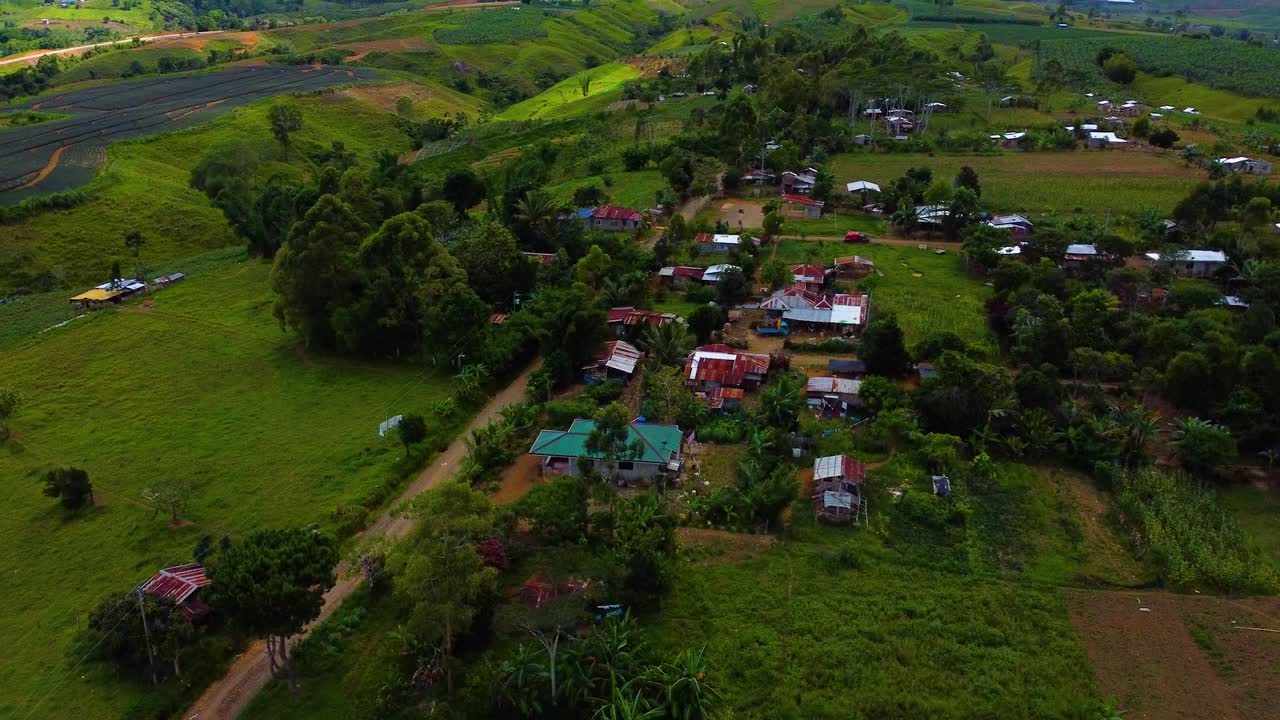 tilt up drone menembak truk yang menuju ke gunung melewati sebuah desa