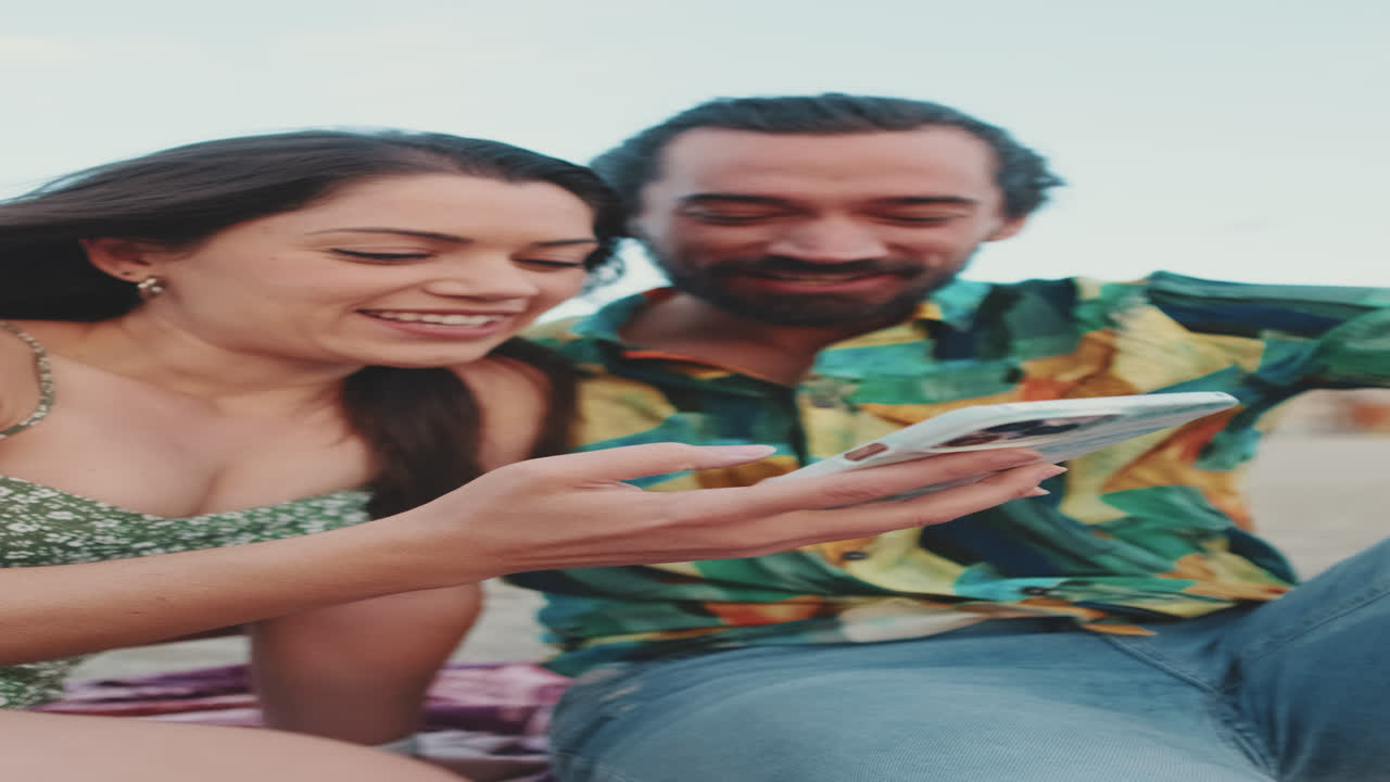 Couple looking at a phone on the beach