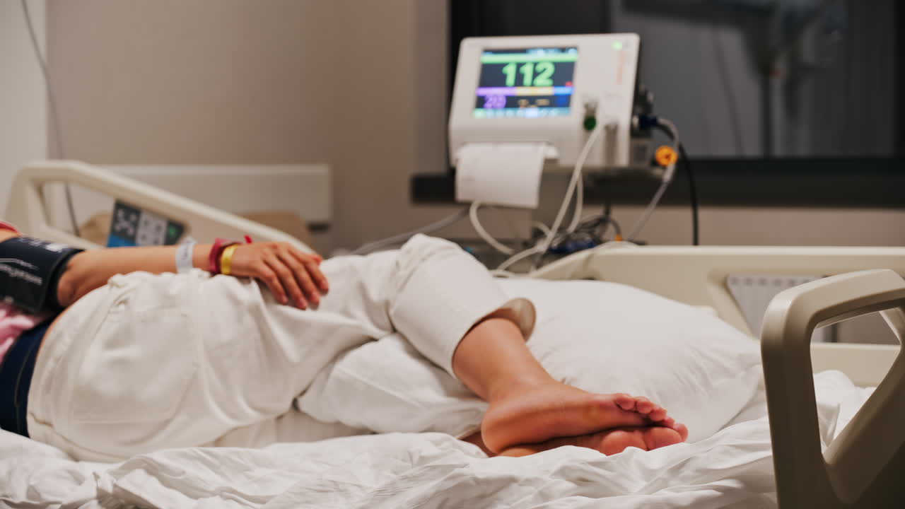 Pregnant woman lying in a hospital bed during a prenatal check-up at the doctor's office