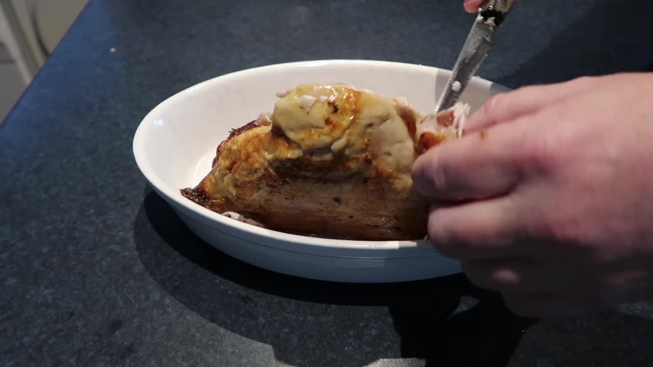 Man cutting or carving a hot roast chicken