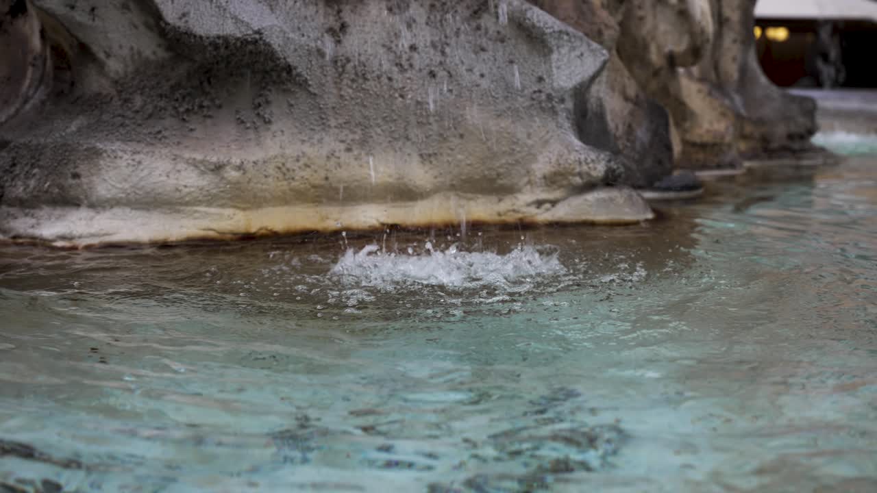 물방울 이 느린 움직임 으로 대리석 분수 의  ⁇  을  ⁇ 고 있다