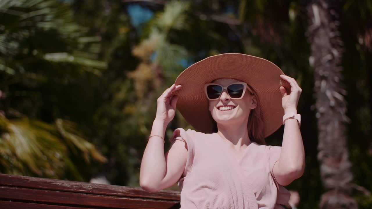 Smiling Woman in Hat Sitting on Park Bench