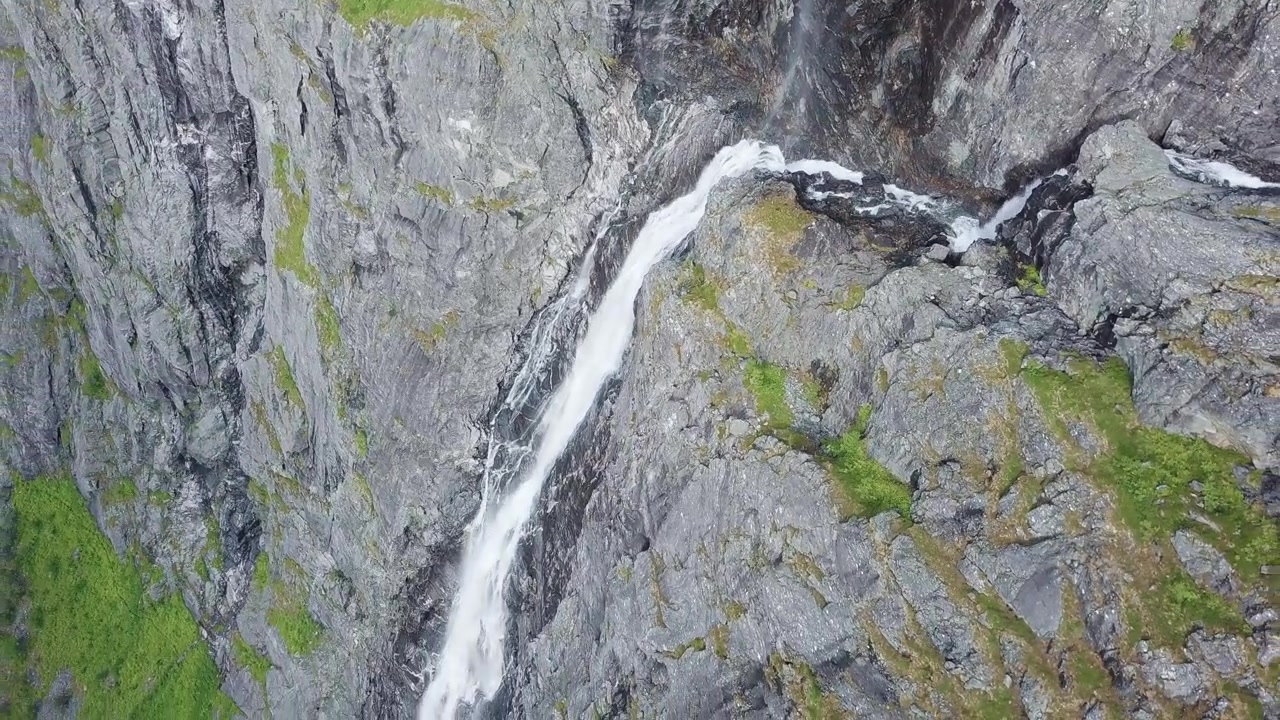 Splendida vista aerea dell'acqua che scorre giù da una scogliera rocciosa vicino al Sentiero dei Troll, Norvegia