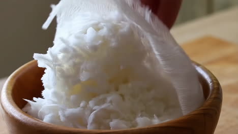 straining liquid into a wooden bowl