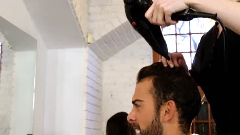 Man-getting-his-hair-dried-with-hair-dryer