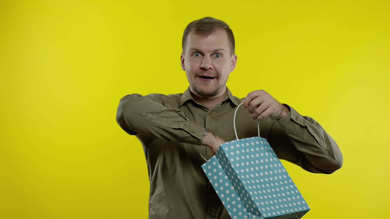 hombre mostrando hasta un 30 por ciento de descuento en la inscripción de la bolsa de compras, disfrutando de descuentos, precios bajos