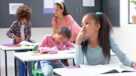 in school, girl daydreaming at desk while classmates and teacher working