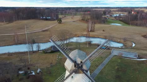 old araisi windmill in latvia aerial shot from above. winter day at sunrise. this is the only windmill in latvia at working order built in 1852. 4k shot