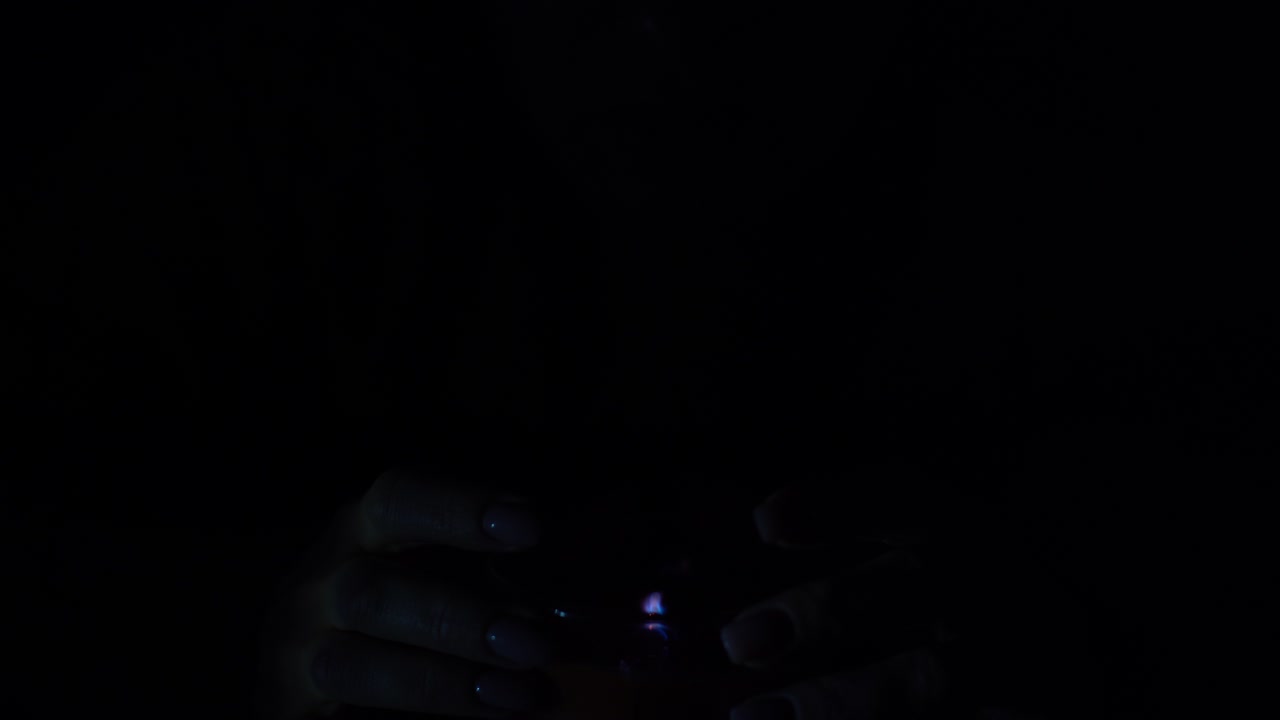 The candle is lit in a glass held by a beautiful woman in black. Isolated on the concept of saving the earth's energy. Earth hour