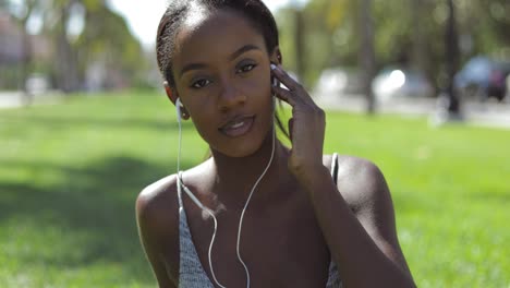 woman adjusting earphone in ear