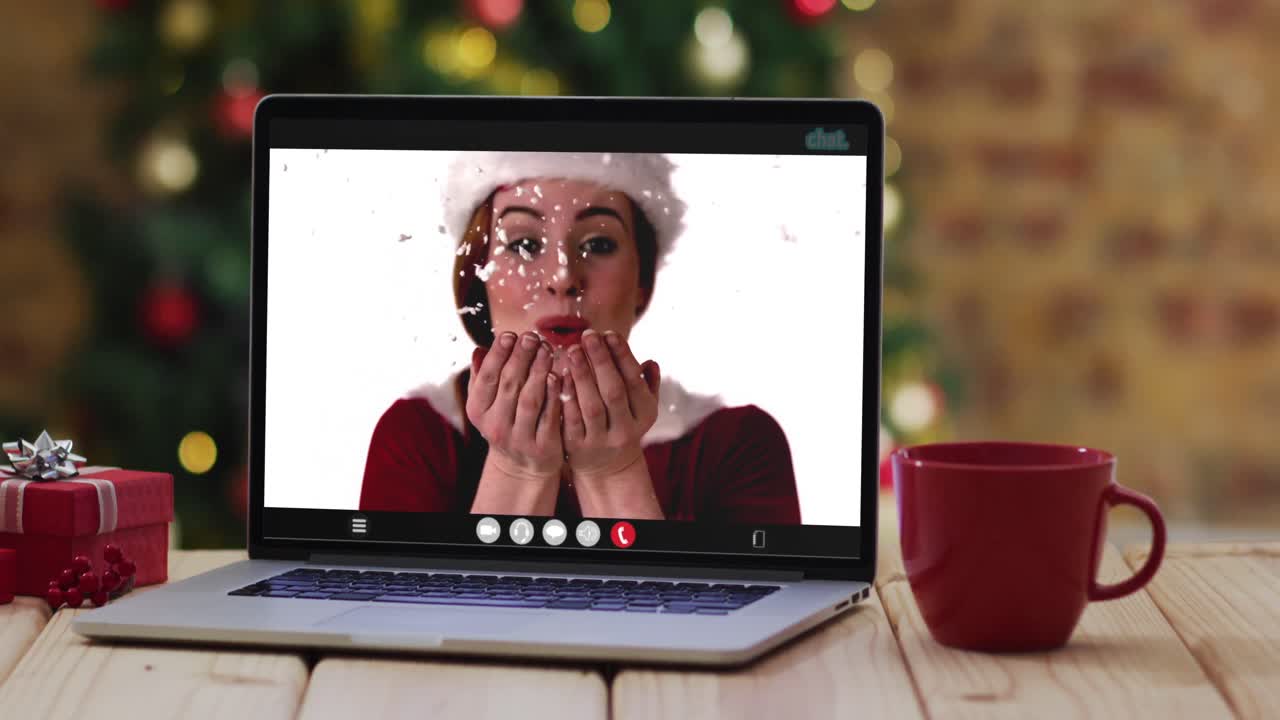 feliz mujer caucásica en disfraz de santa en videollamada en computadora portátil, con decoraciones de navidad y árbol