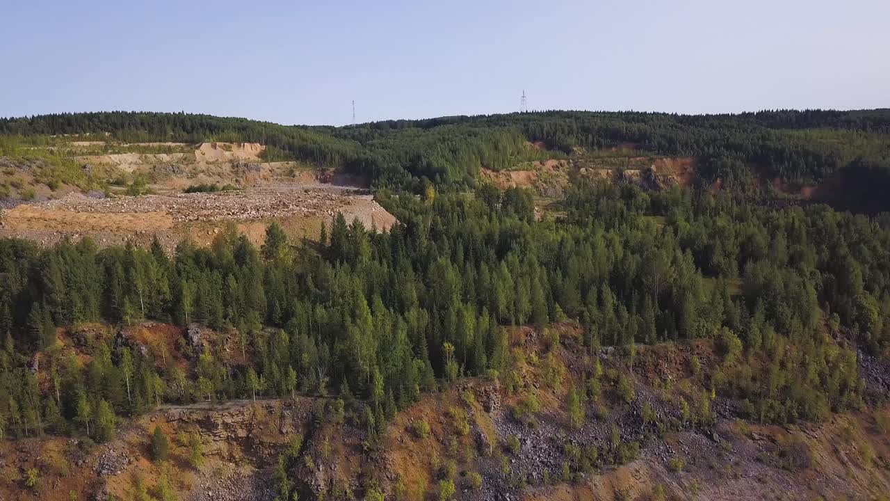 Flygfoto över ett stenbrott och omgivande skog
