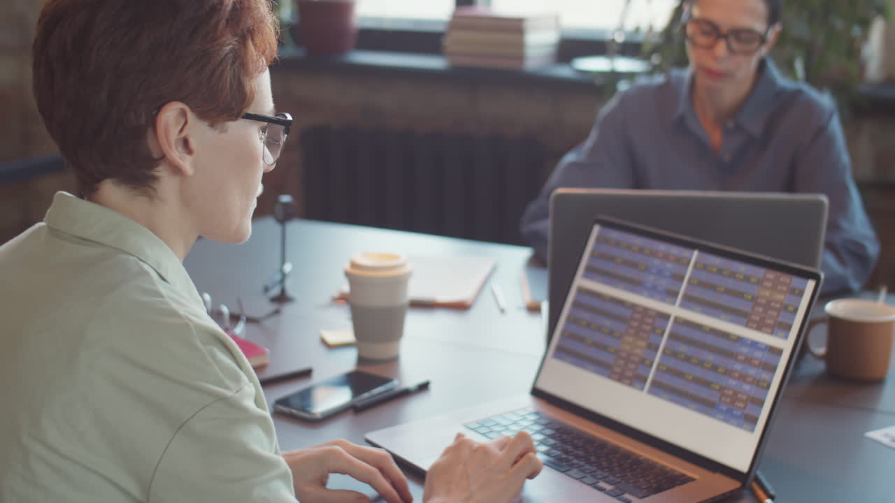 Businesswomen collaborating on laptop in an office