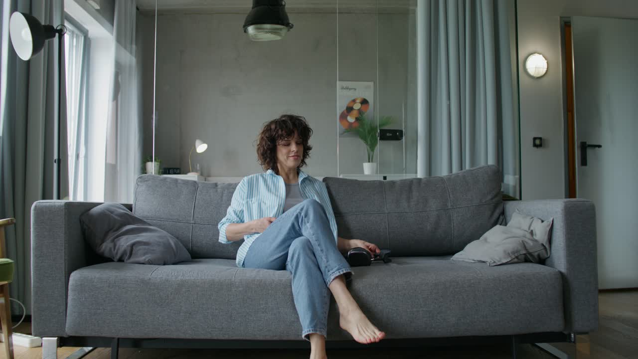 현대적인 거실에서 소파에서 춤을 추고 휴식을 취하는 여자