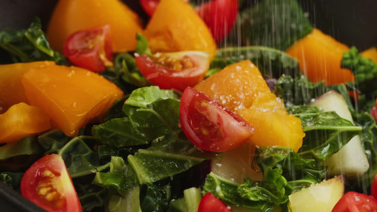 Sprinkling Salt on a Colorful Fresh Vegetable Salad