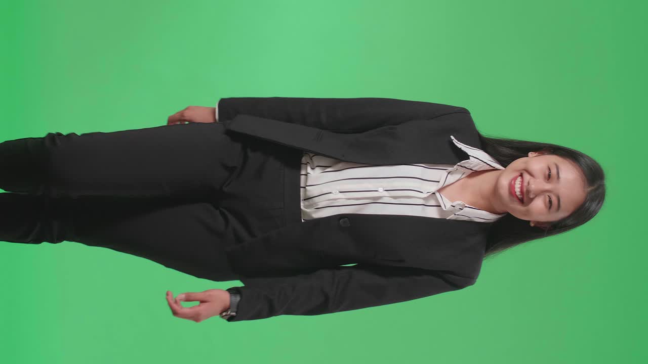 A Smiling Asian Business Woman Walking Through Green Screen In The Studio