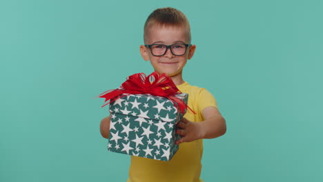 Smiling-toddler-children-boy-presenting-birthday-gift-box-stretches-out-hands,-offer-wrapped-present