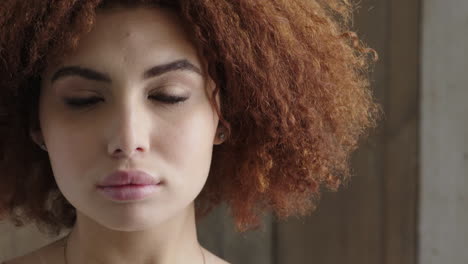 close up portrait of beautiful young woman pensive contemplative looking at camera stylish afro hairstyle