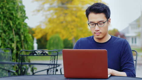 Un-Joven-Asiático-Trabaja-Con-Una-Computadora-Portátil-3