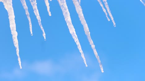 icicles hanging from a roof against a blue sky