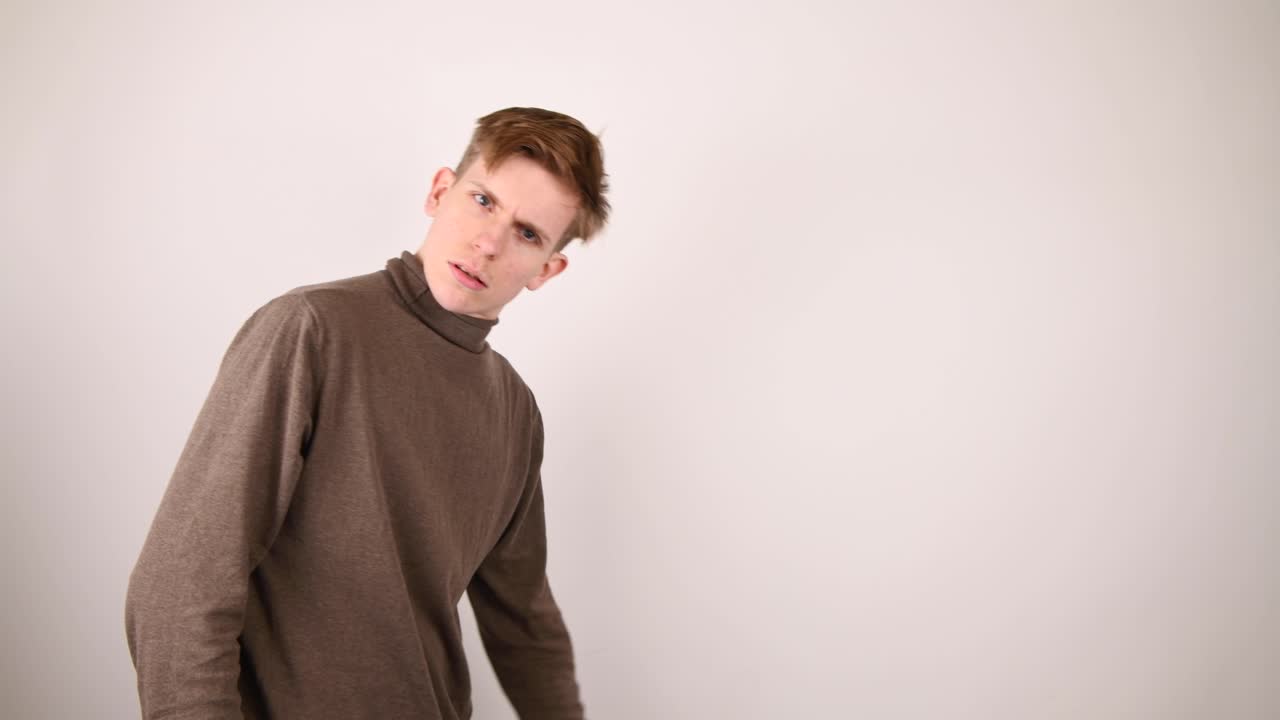 한 청년이 걸어가며 가운데 손가락과 손을 흔들며 작별인사를 한다