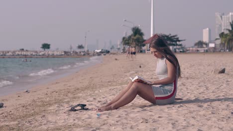 Schöne-Dame-Mit-Langen-Dunklen-Haaren-Liest-Buch-Am-Sandstrand