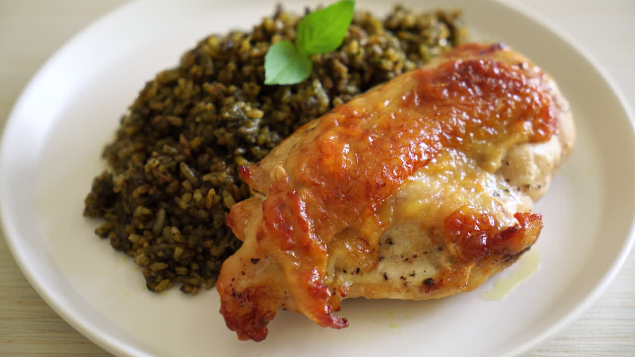 riso fritto al pesto con pollo alla griglia su piatto bianco