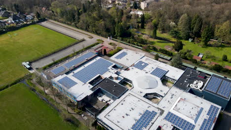 aerial overview of large high school with solar panels on rooftop