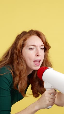 woman speaking into a megaphone on a yellow background