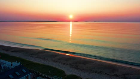 vista aérea de drones de hermosas casas de playa y amanecer sobre maine casas de vacaciones y colores que se reflejan en las olas del océano a lo largo de la costa atlántica de nueva inglaterra