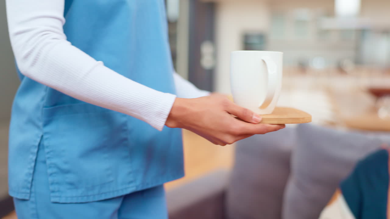 Caregiver Serving Tea and Cookies to Elderly Patient